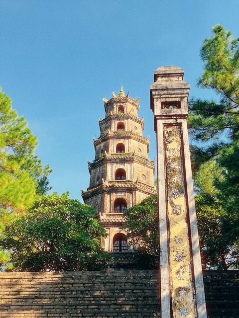 A tall old pagoda tower and a stone stele among green trees — shot on A HUE