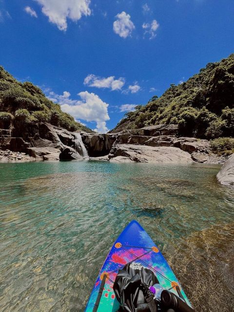 A kayak on a clear green river between rocky hills — shot on A NFX